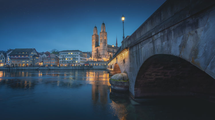 Grossmunster Church and Munsterbrucke Bridge at Night - Zurich, Switzerland