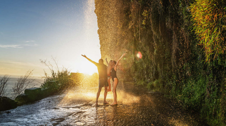 A refreshing moment under a hidden coastal waterfall