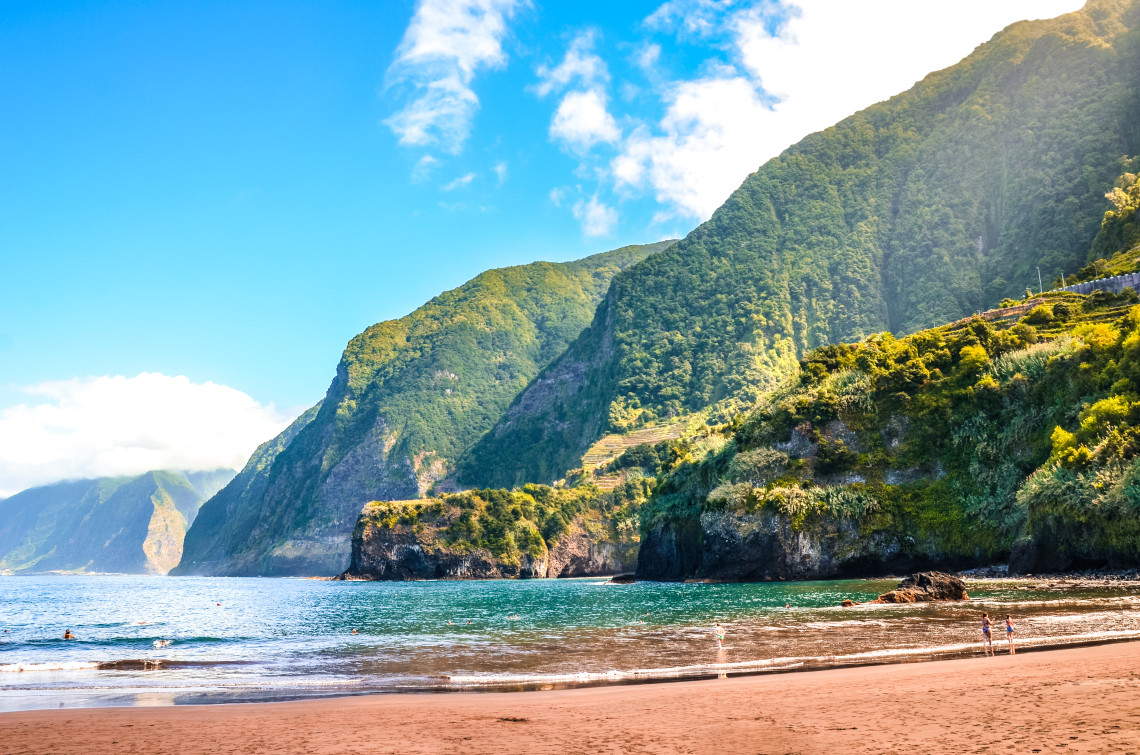Beautiful sandy beach in Madeira, Portugal, with turquoise waters and dramatic green cliffs, a perfect spot for relaxation and nature on an all inclusive holiday.