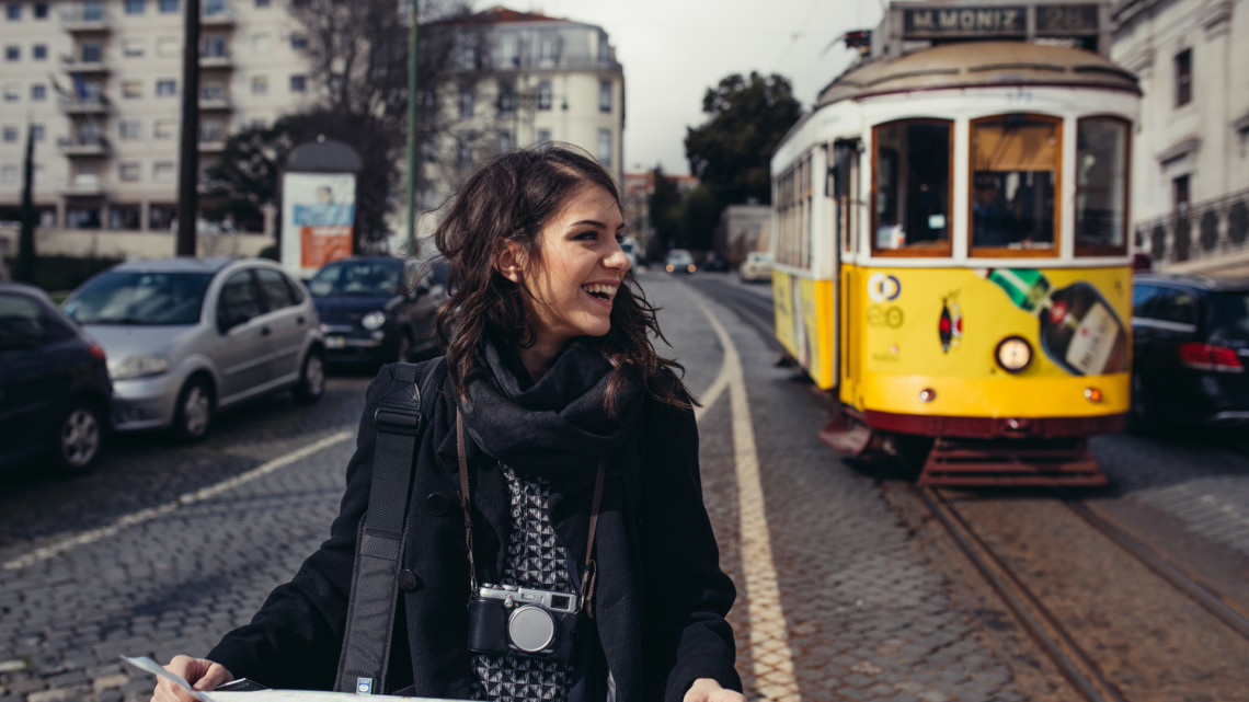 Woman joyfully cycling through the vibrant streets of Lisbon.