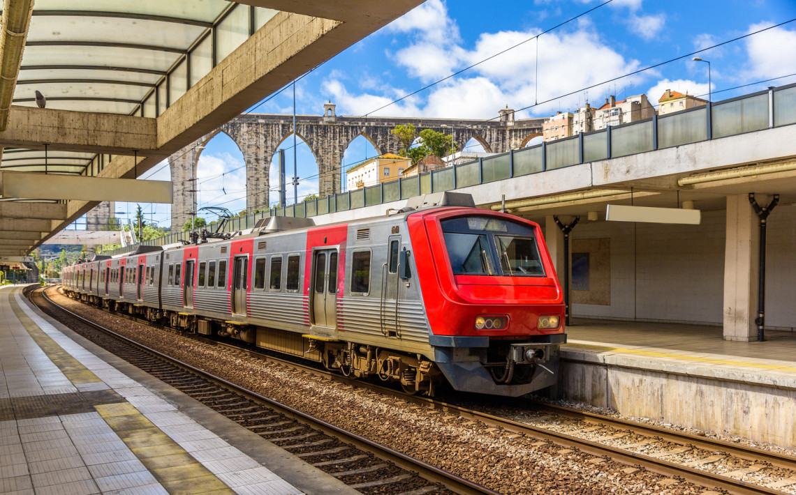 Train traveling along the tracks with Lisbon