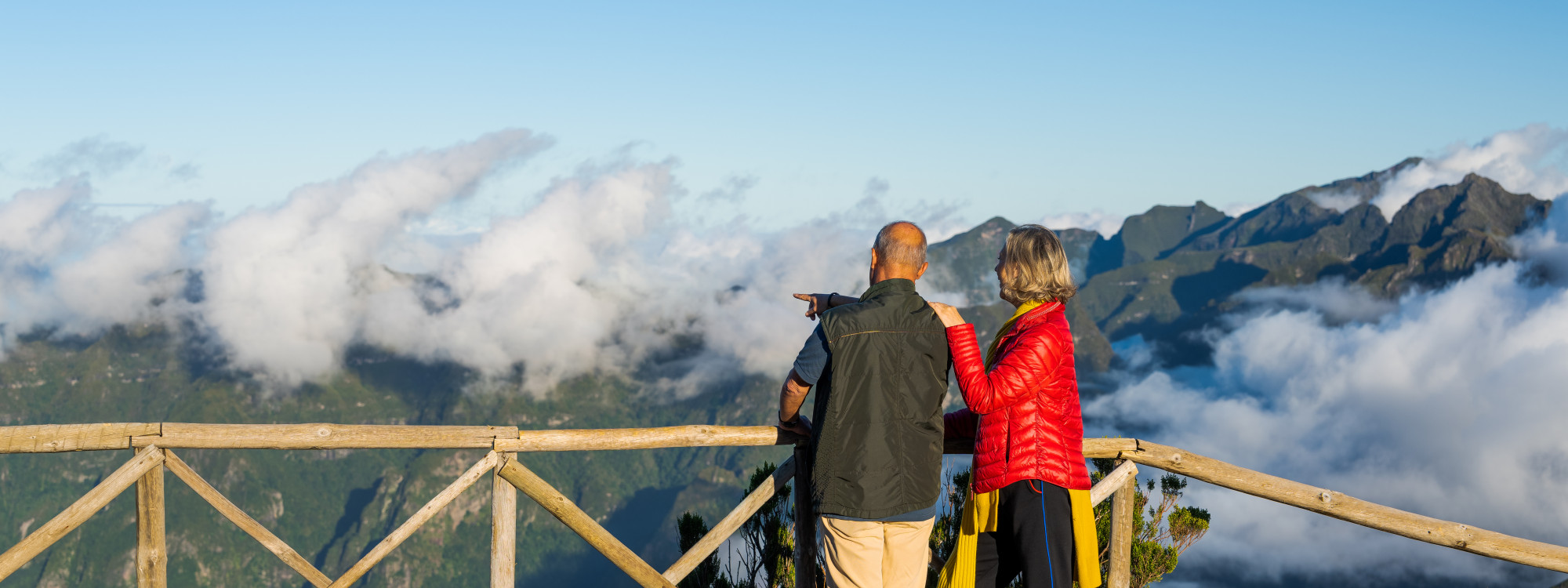 Bica da Cana Viewpoint in Madeira – Scenic Mountain Views Couple admiring mountain views from Bica da Cana viewpoint in Madeira, Portugal, surrounded by clouds and dramatic peaks