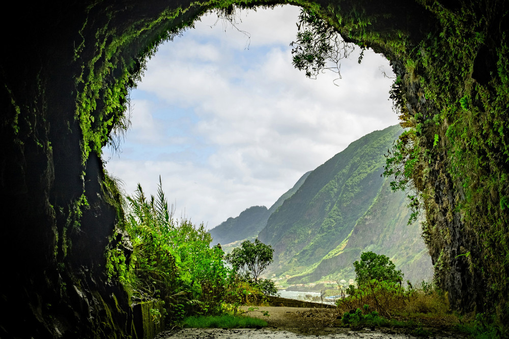 Scenic Cave Opening with Mountain Views – Hiking in Madeira Island Mountain view framed by a cave on a hiking trail in Madeira Island, Portugal