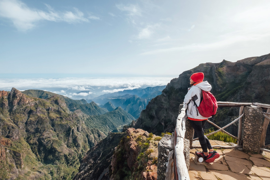 Mountain Hiking at Pico do Arieiro – Madeira Island Adventure Viewpoint Hiker at Pico do Arieiro viewpoint on Madeira Island, Portugal, overlooking dramatic mountain peaks and a sea of clouds