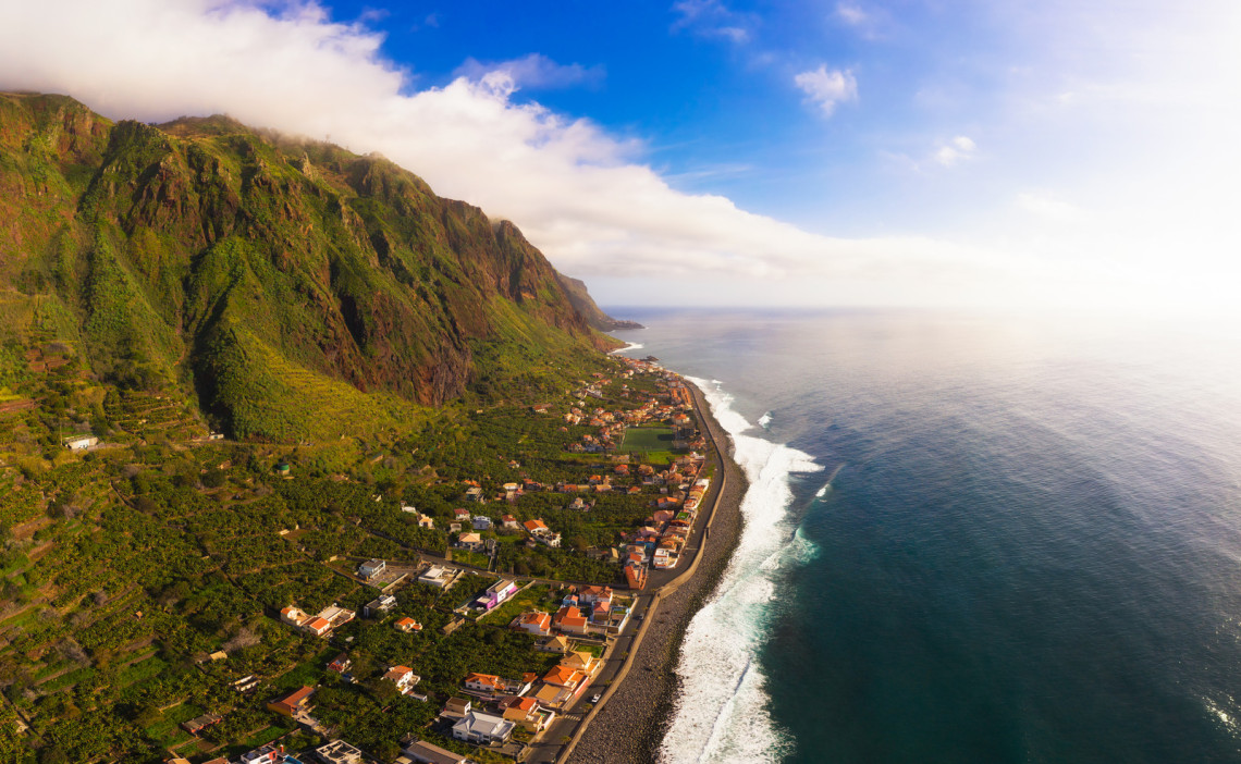 Aerial view of a narrow coastal road during the sunset. Winding path in the western part of the Madeira Island, Portugal, Europe.