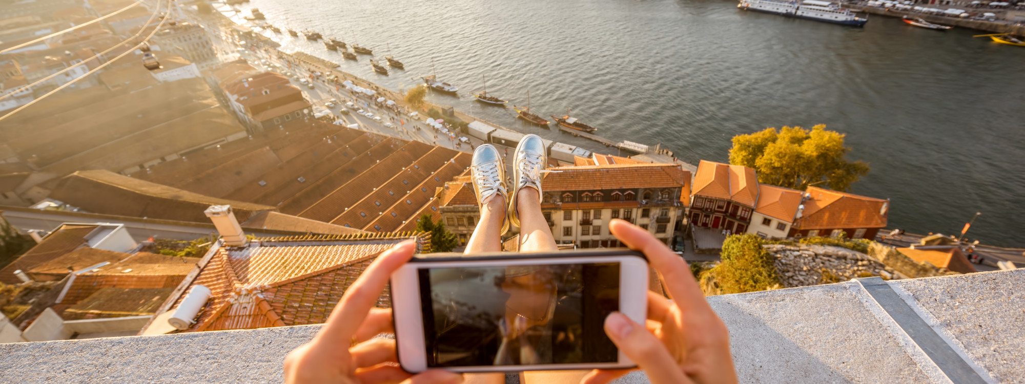 Capturing the view of Porto and the Douro River from above Traveler taking a photo with a smartphone while overlooking the Douro River and Porto’s riverside rooftops