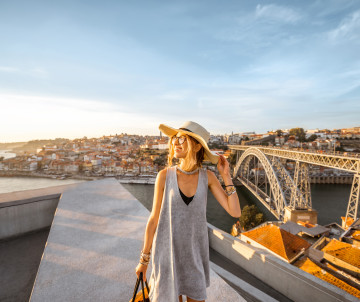 Traveler enjoying Porto’s skyline and the Dom Luís I Bridge at sunset, featured in Black Friday vacation packages.