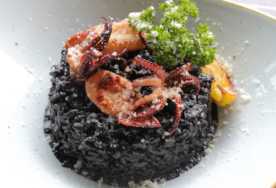 Black paella with squid ink from Spain called Arroz negro squid-with-black-rice-spain-food-arrós-negre