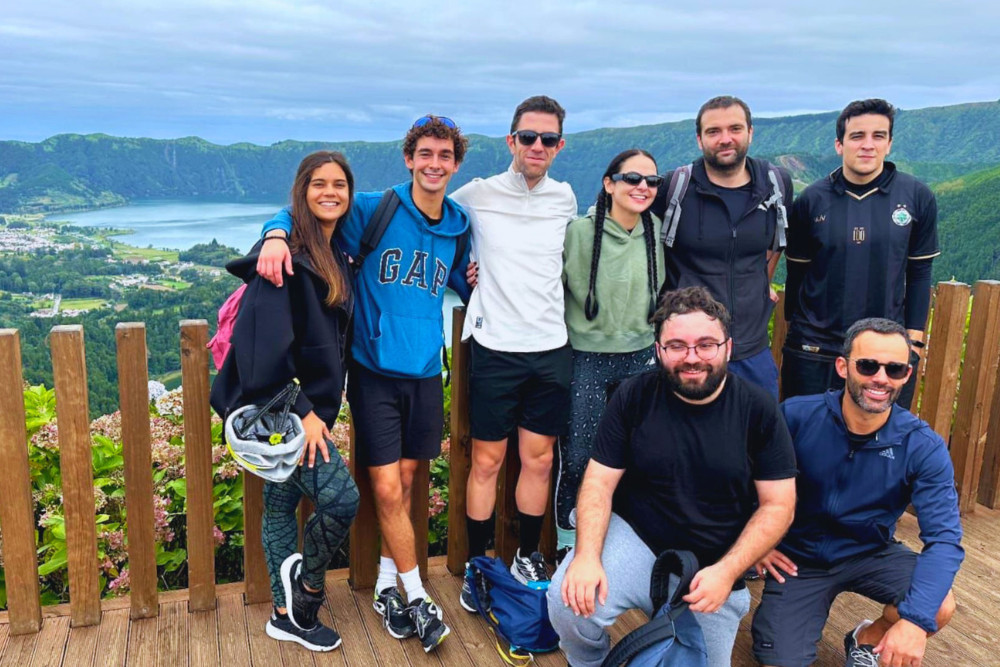 Group Tour at Sete Cidades – São Miguel Island, Azores Smiling group of travelers at a scenic viewpoint overlooking the twin lakes of Sete Cidades on São Miguel Island, Azores — a popular stop on guided group tours through the volcanic landscape.