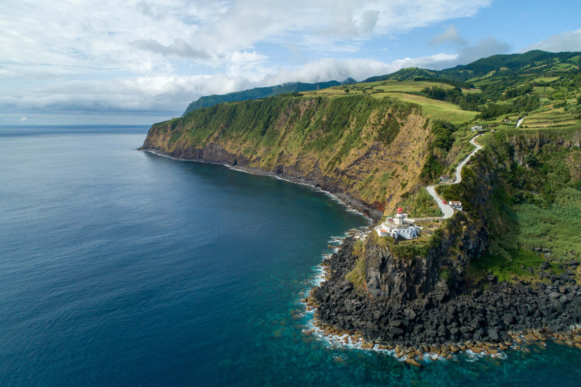 Panoramic Coastal View of Vista dos Barcos and Ponta do Arnel Lighthouse in Nordeste, São Miguel Island Aerial view of Vista dos Barcos viewpoint and the iconic Ponta do Arnel Lighthouse perched on the cliffs of Nordeste, São Miguel Island, Azores.