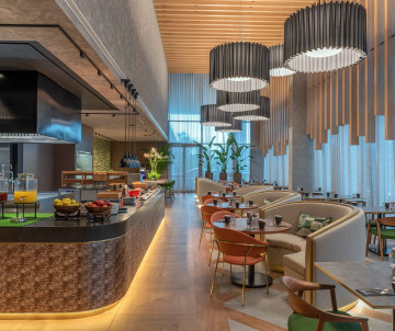 Elegant Breakfast Area at DoubleTree by Hilton São Miguel Island Contemporary restaurant at DoubleTree by Hilton São Miguel Island featuring modern decor, cozy seating, and a vibrant breakfast buffet with fresh juices and fruits.