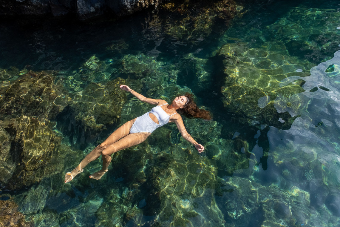 Woman relaxing in a clear natural pool on São Miguel Island, Azores Woman floating in natural pool São Miguel Azores