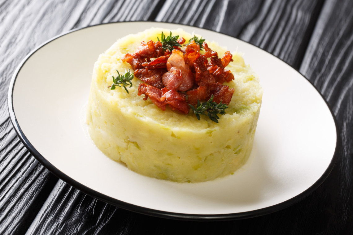 Tasty Trinxat mashed potatoes and green cabbage with fried bacon closeup in a plate. tasty-trinxat-mashed-potatoes-and-green-cabbage-with-fried-bacon-closeup-in-a-plate-horizontal